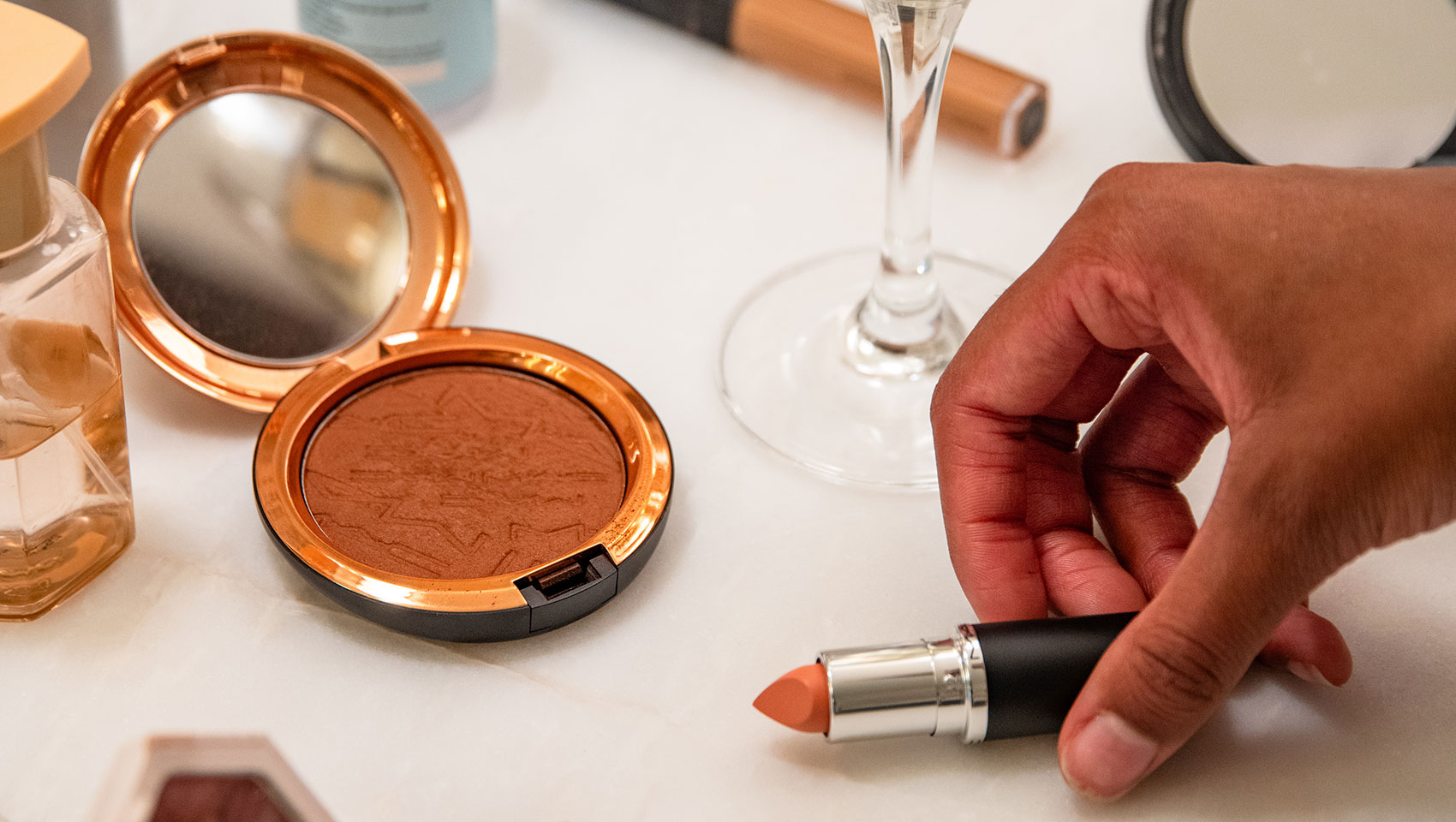 A glass of sparkling wine and makeup at kimpton hotel monaco dc