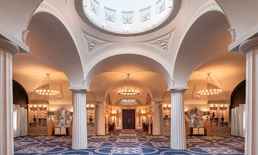 The Paris Ballroom captivates with a soaring dome skylight, classical columns, and elegant mirrored archways